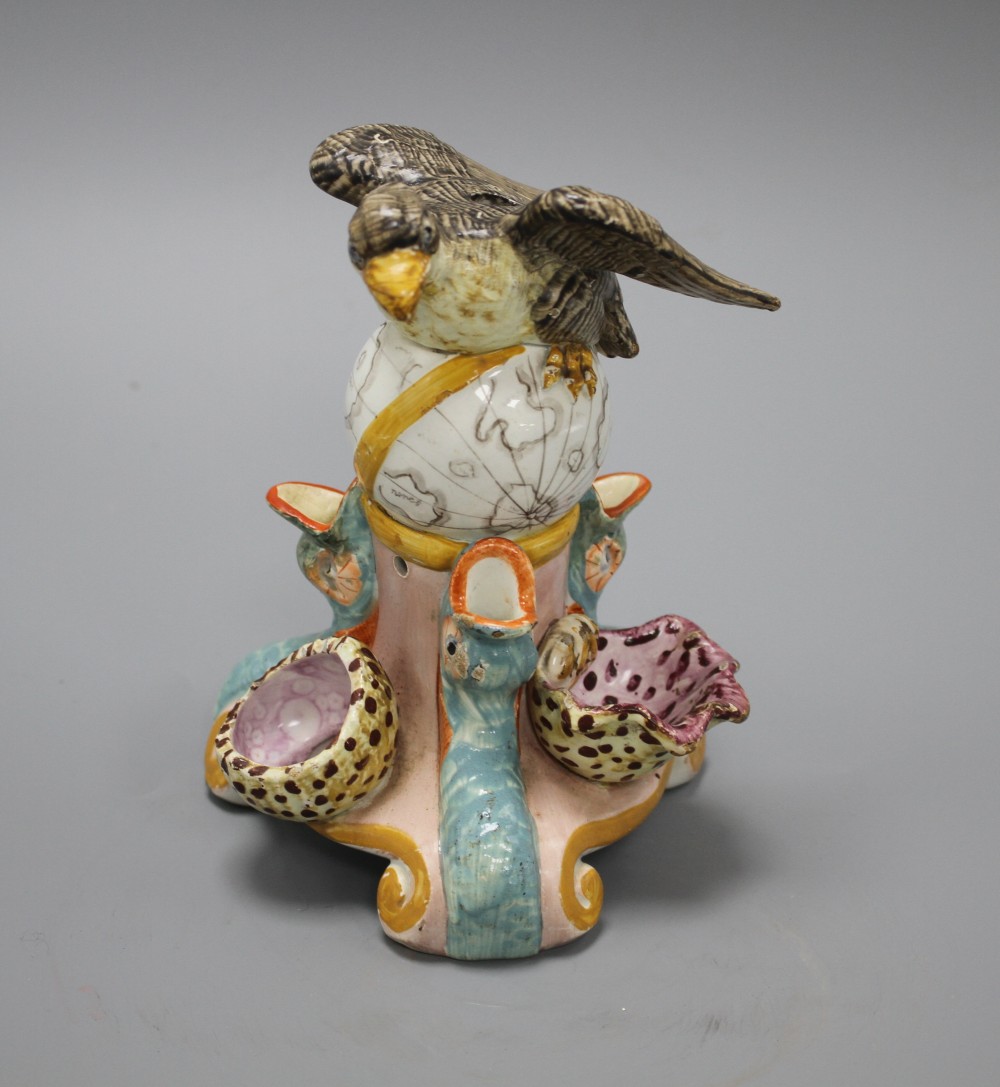 An early 19th century Staffordshire inkwell, modelled with an eagle perched upon a globe above three dolphins and shells, height 15cm